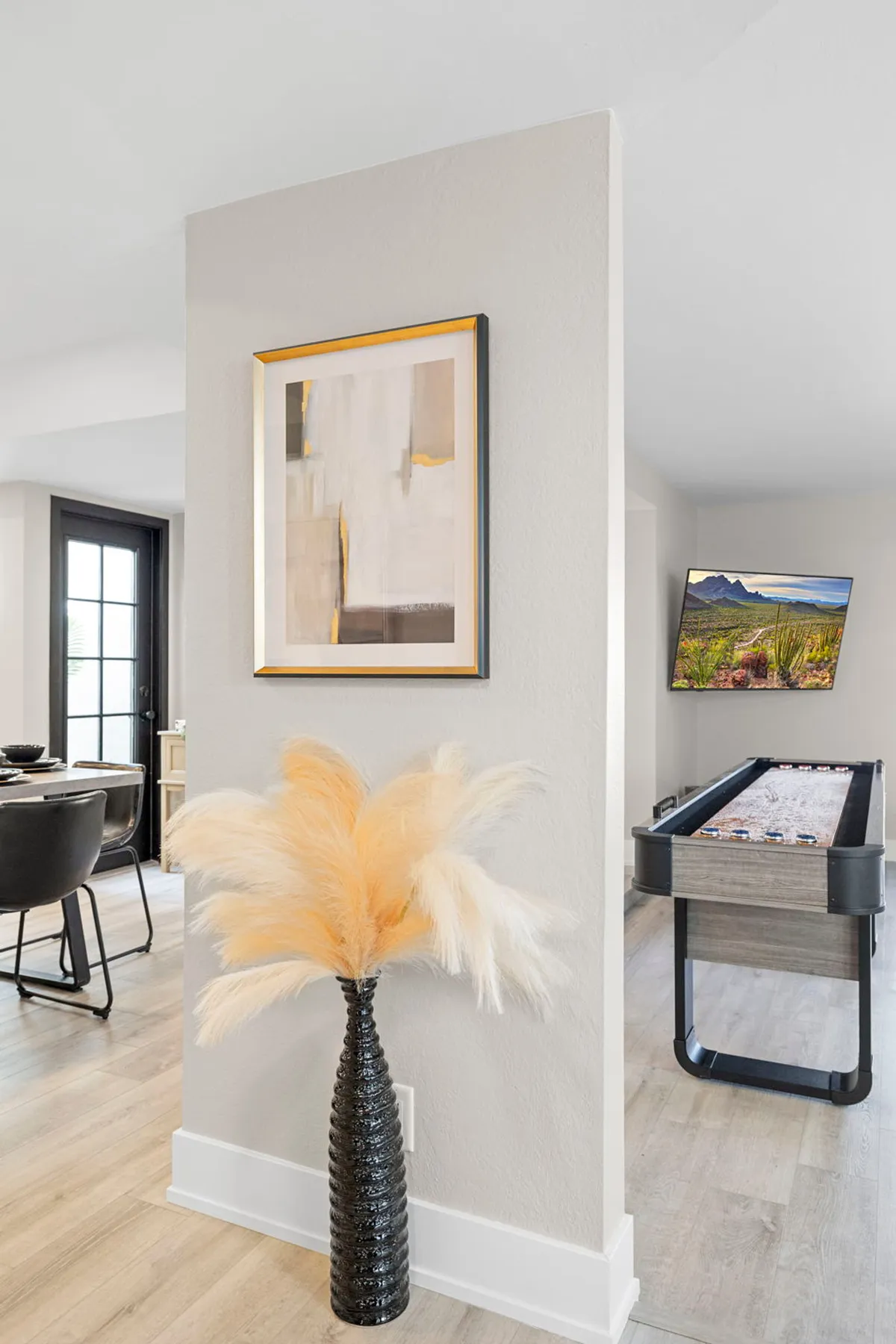 A stylish clubhouse interior with a pool table, abstract art on the wall, and a floral arrangement. The background hints at an active, social environment where residents can play games, socialize, or relax during community events.